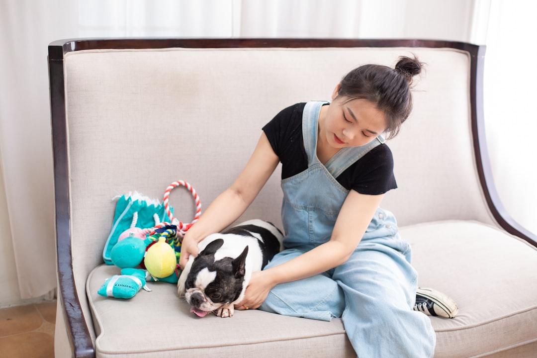 Happy woman enjoying clean, pet-hair-free furniture with her bulldog